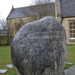 This granite stone called Ferann Dòmhnuill comes from Glen Glass in the heart of Munro Country. It was brought down by the glaciers of the last Ice Age. Geologists call it a "Glacial Erratic". It commemorates Donald O'Caan, Prince of Fermanagh, first chief of Clan Munro. He and his followers are said to come from the River Ro in Northern Ireland to help King Malcolm II of Scotland (1005-34) drive out Viking Invaders. The King granted Donald all the land between Dingwall and the River Alness in return for his services. To this day the land is known as Ferindonald (Fearann Dòmhnuill in Gaelic) or Donald's land. A millennium later it is still home to many Munros and spiritual home to all of those of Munro descent across the world.